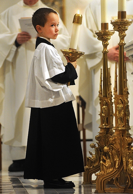 Eight-year-old altar boy David Haseltine, of Amherst, serves at St. Joseph Cathedral during the Evening Mass of the Lord's Supper. (Dan Cappellazzo/Staff Photographer)